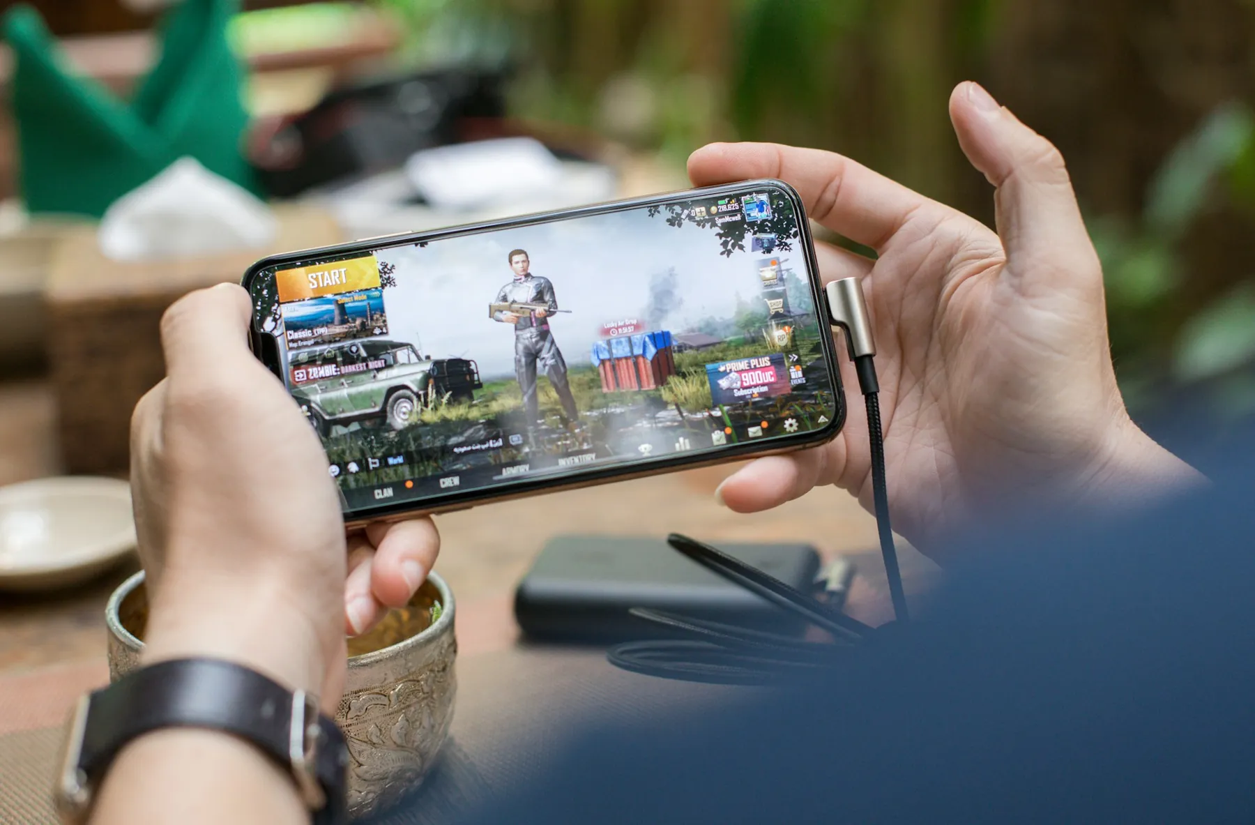 Hands holding a phone sideways, playing a mobile game.